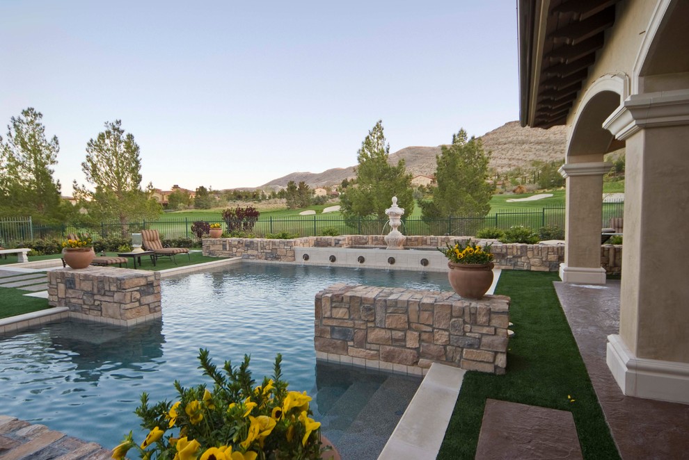 Inspiration for a large mediterranean back custom shaped swimming pool in Las Vegas with a water feature.