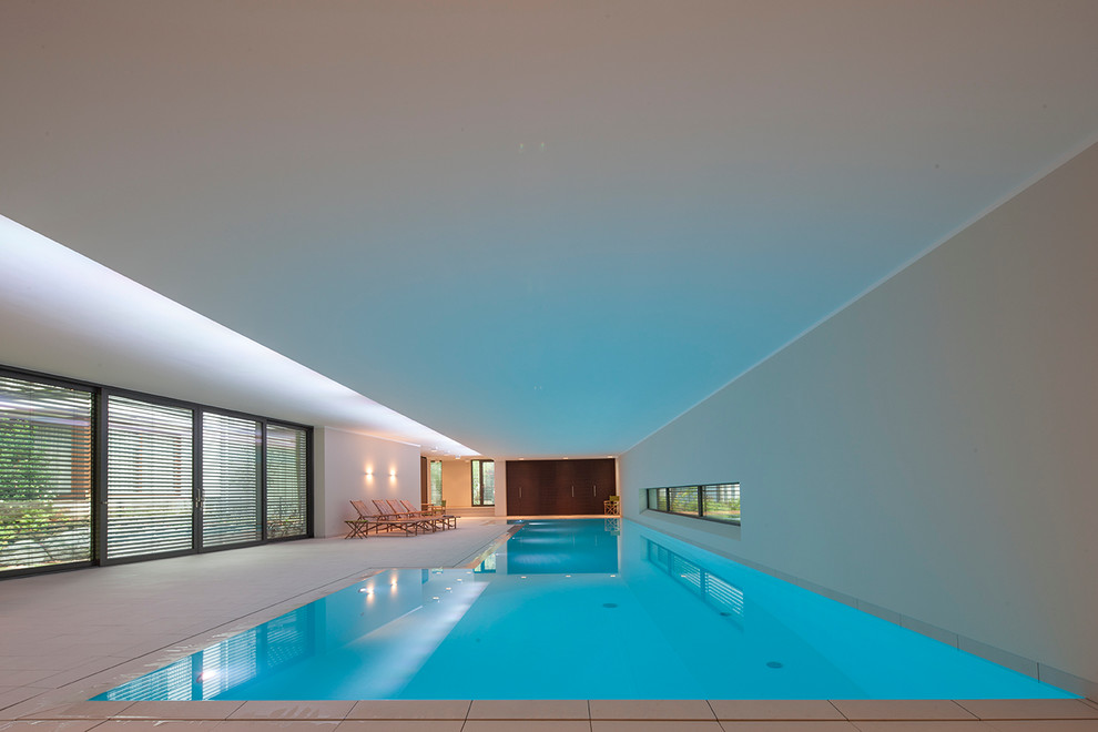 Foto di un'ampia piscina coperta minimalista a "L" con piastrelle