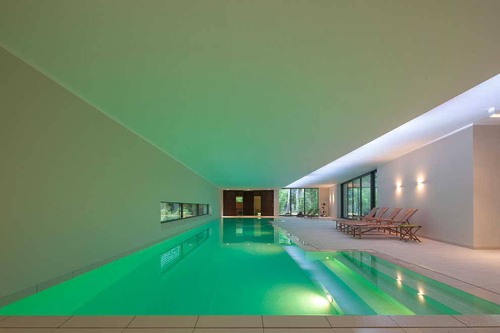 Cette image montre une très grande piscine intérieure minimaliste sur mesure avec du carrelage.