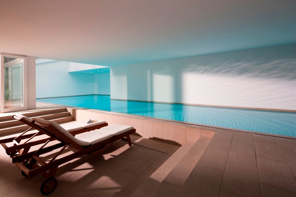 Großer Moderner Indoor-Pool in L-Form mit Betonplatten in Dresden