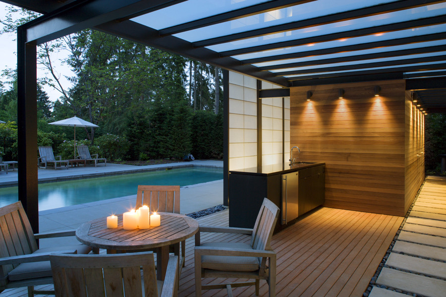 Example of a large trendy backyard stone and rectangular pool house design in Seattle
