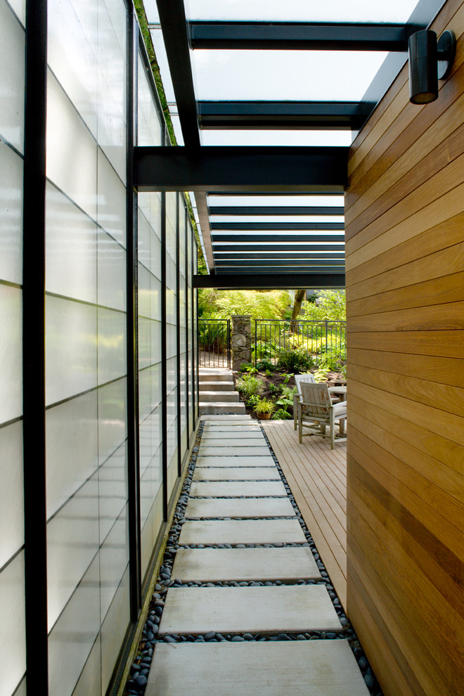 Foto de casa de la piscina y piscina contemporánea grande rectangular en patio trasero con adoquines de piedra natural