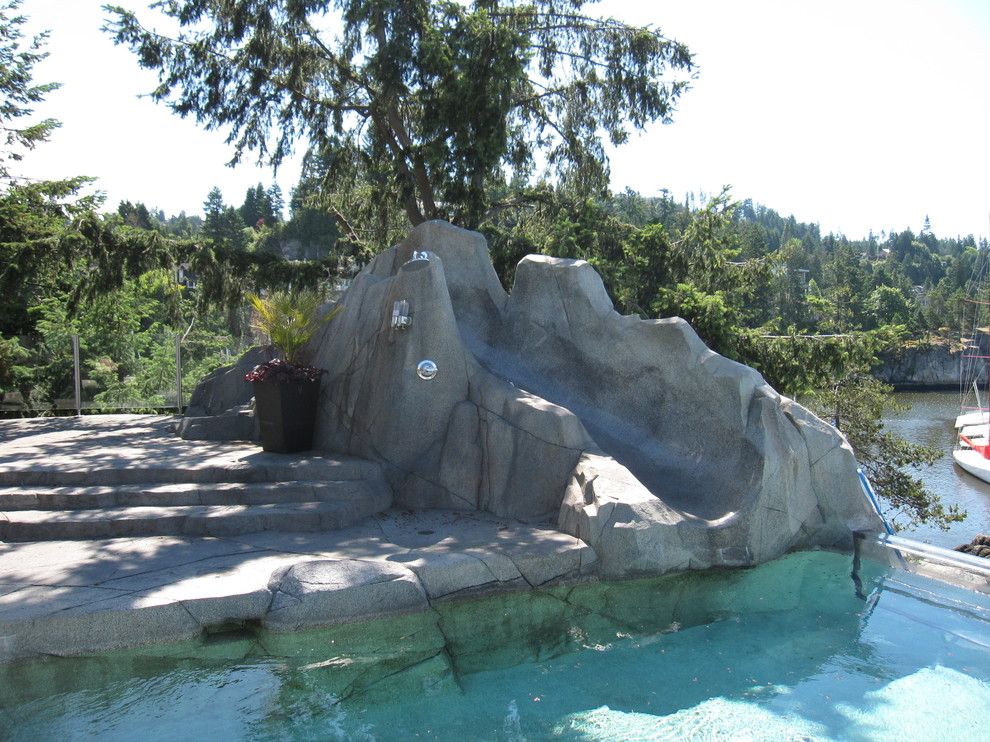 Esempio di una piscina naturale stile marinaro di medie dimensioni e dietro casa con un acquascivolo e cemento stampato