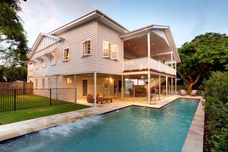 Großes Landhaus Sportbecken hinter dem Haus in L-Form mit Natursteinplatten in Brisbane