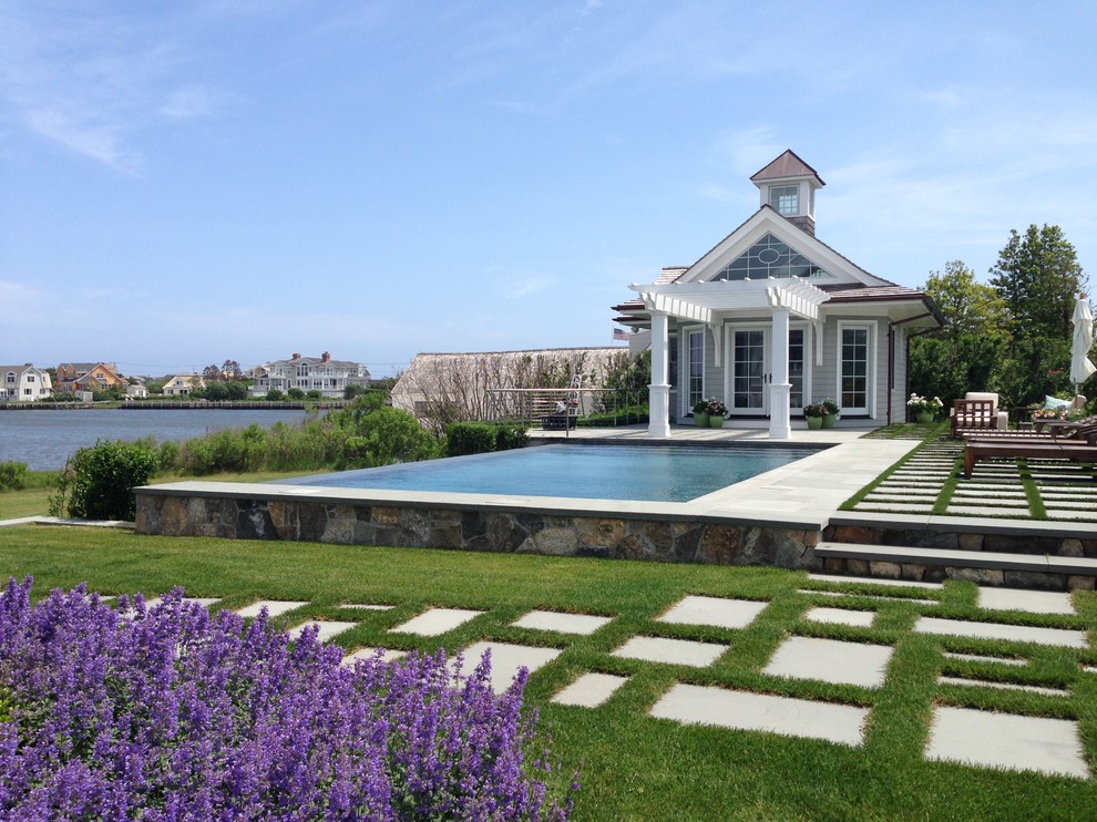 Imagen de casa de la piscina y piscina infinita marinera de tamaño medio rectangular en patio trasero con adoquines de hormigón