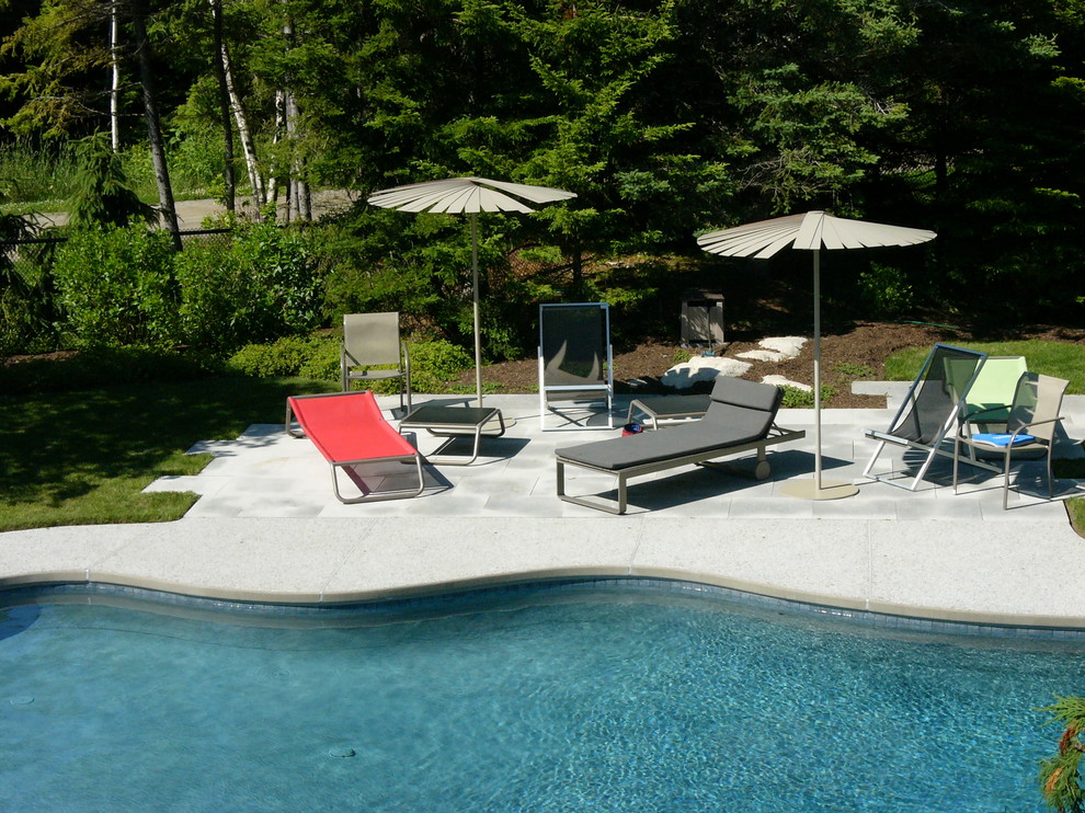 Ispirazione per un'ampia piscina monocorsia minimalista a "C" dietro casa con cemento stampato