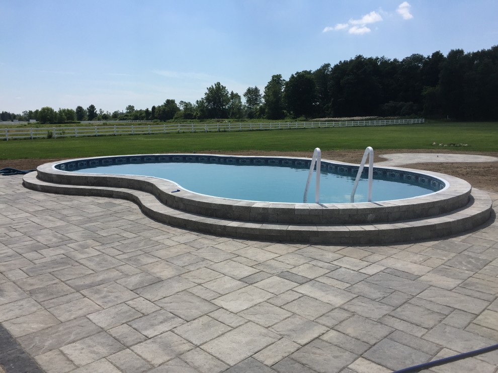 Foto di una piccola piscina monocorsia classica a "C" dietro casa con cemento stampato