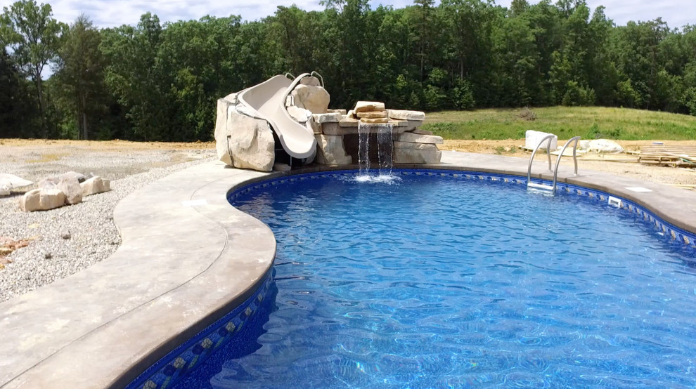 Idee per una grande piscina naturale moderna personalizzata nel cortile laterale con un acquascivolo e lastre di cemento