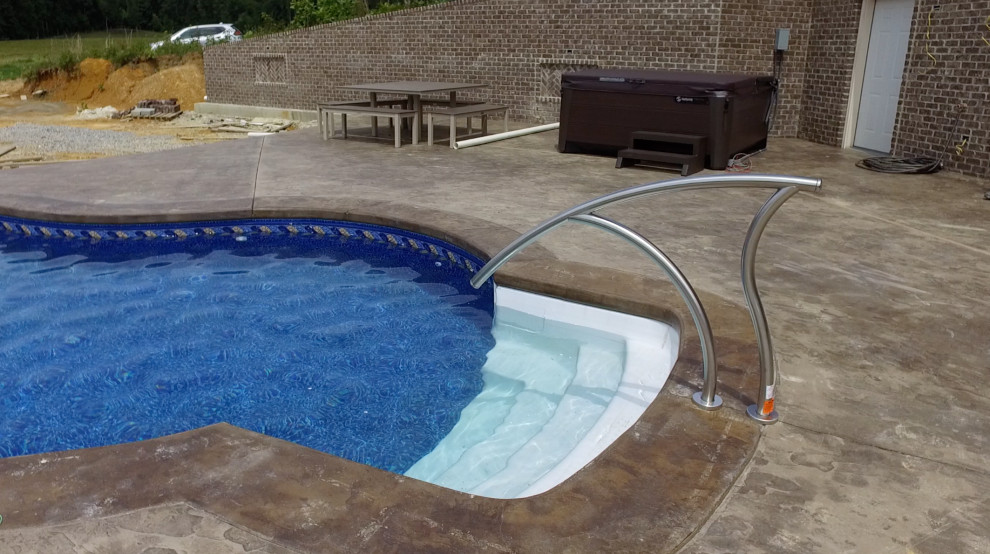 Стильный дизайн: большой естественный бассейн произвольной формы на боковом дворе в стиле ретро с водной горкой и покрытием из бетонных плит - последний тренд