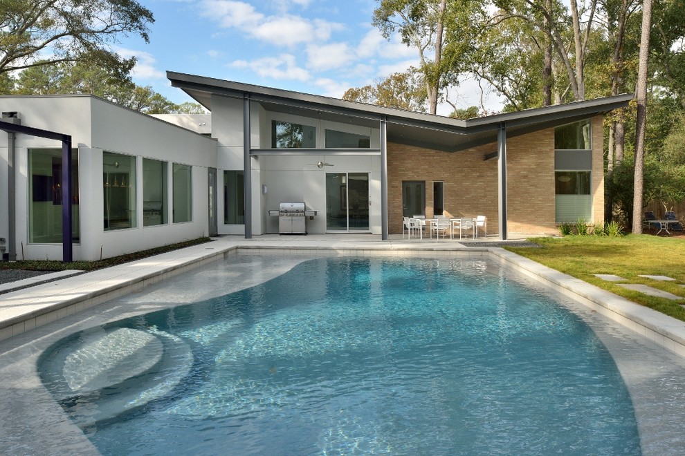 This is an example of a contemporary rectangular swimming pool in Houston with a bbq area.