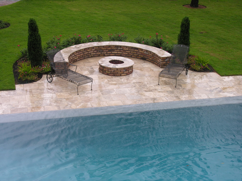 На фото: бассейн-инфинити на заднем дворе в стиле неоклассика (современная классика) с покрытием из плитки с