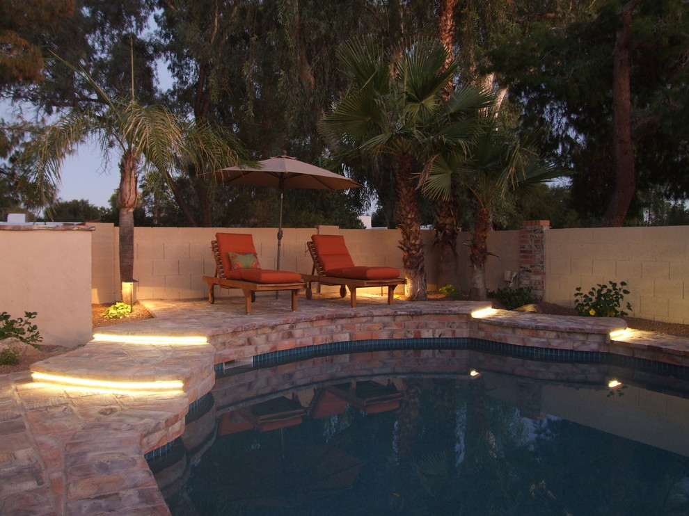 Tuscan brick and custom-shaped pool photo in Phoenix