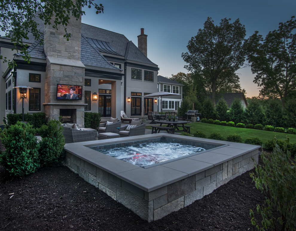 This is an example of a small classic back rectangular natural hot tub in Chicago with a shelter and natural stone paving.