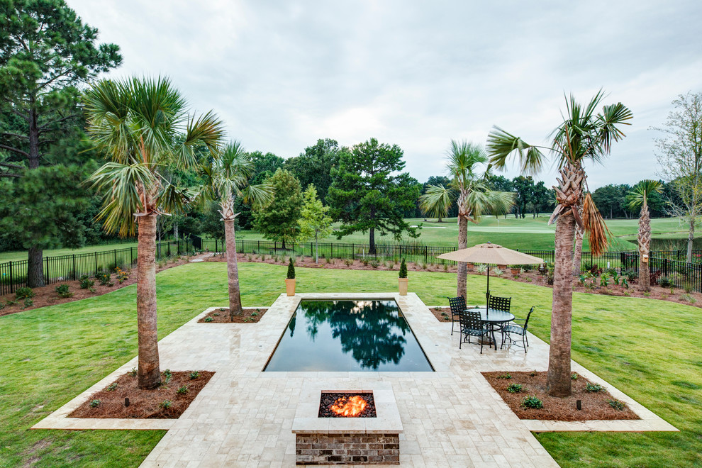 Diseño de piscina con fuente tradicional de tamaño medio rectangular en patio trasero con adoquines de piedra natural