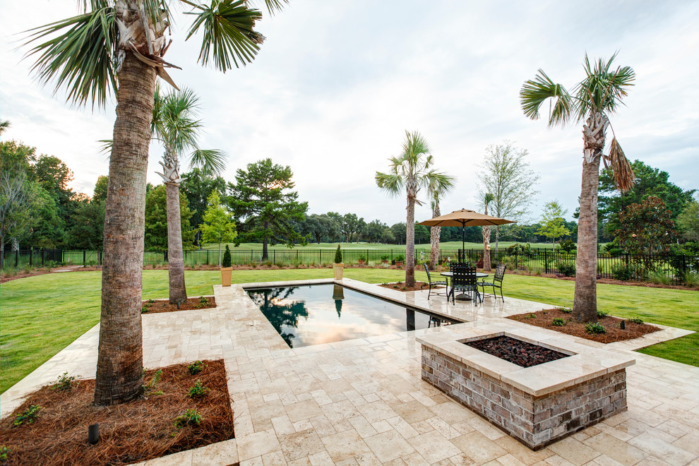 Immagine di una piscina tradizionale rettangolare di medie dimensioni e dietro casa con fontane e pavimentazioni in pietra naturale