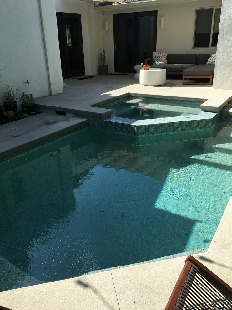 На фото: маленький прямоугольный бассейн на заднем дворе в стиле фьюжн с покрытием из бетонных плит для на участке и в саду