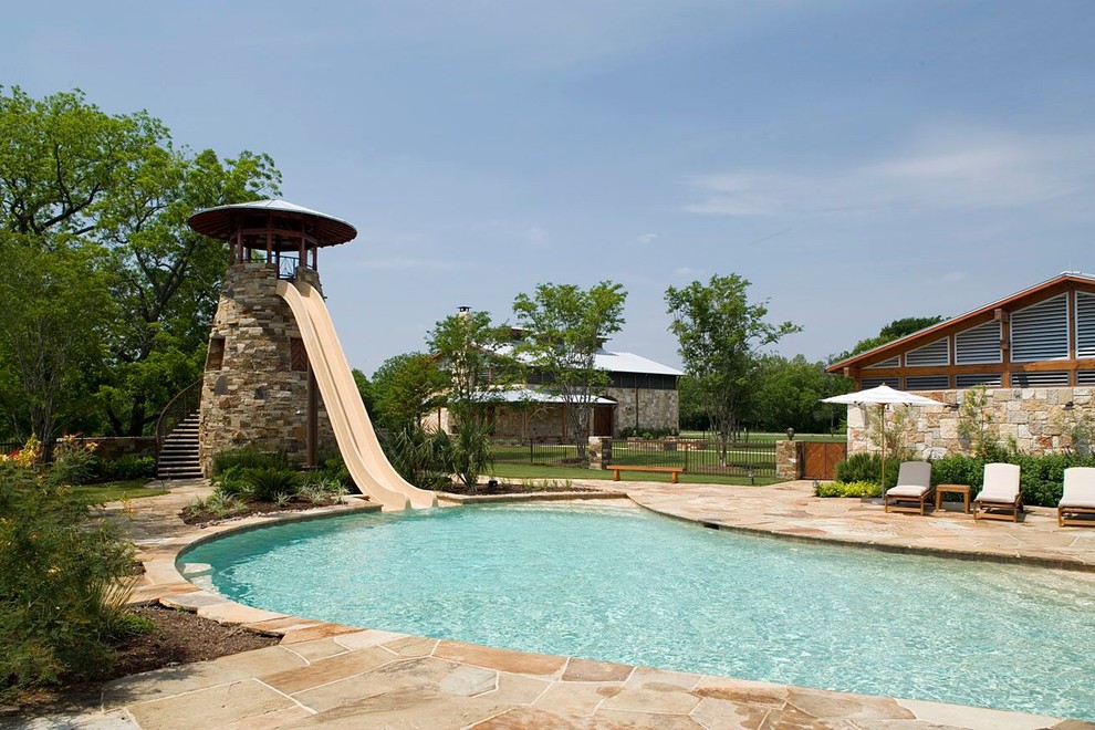 Esempio di una piscina naturale stile rurale personalizzata di medie dimensioni e dietro casa con un acquascivolo e pavimentazioni in pietra naturale