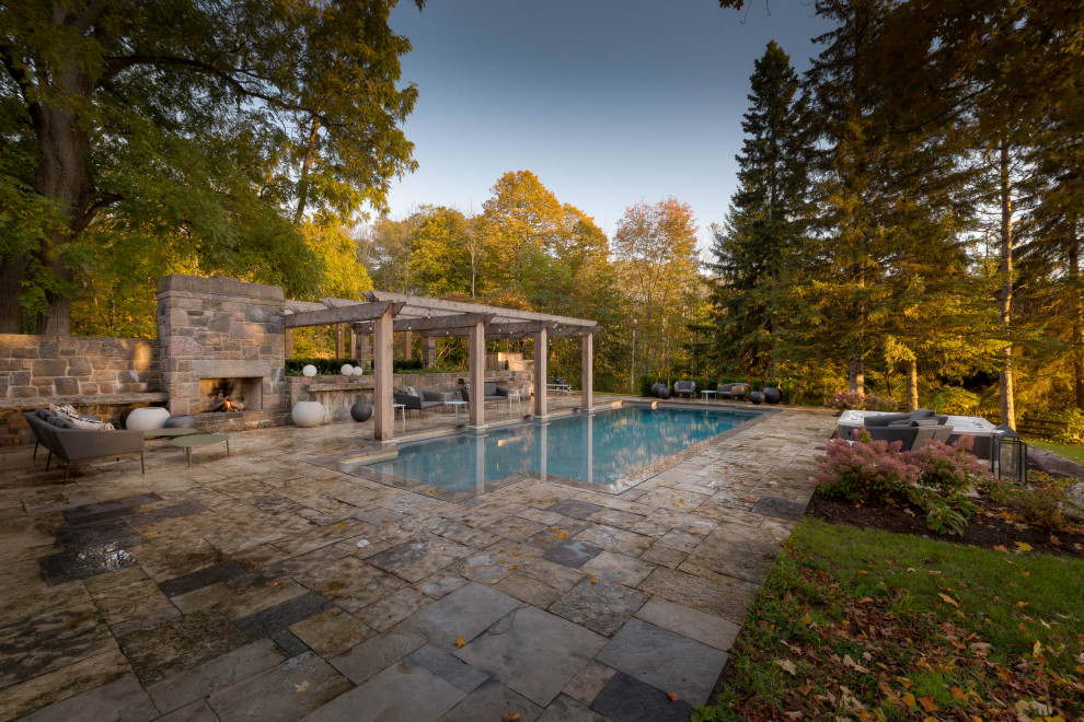 Large cottage backyard stone and rectangular hot tub photo in Toronto