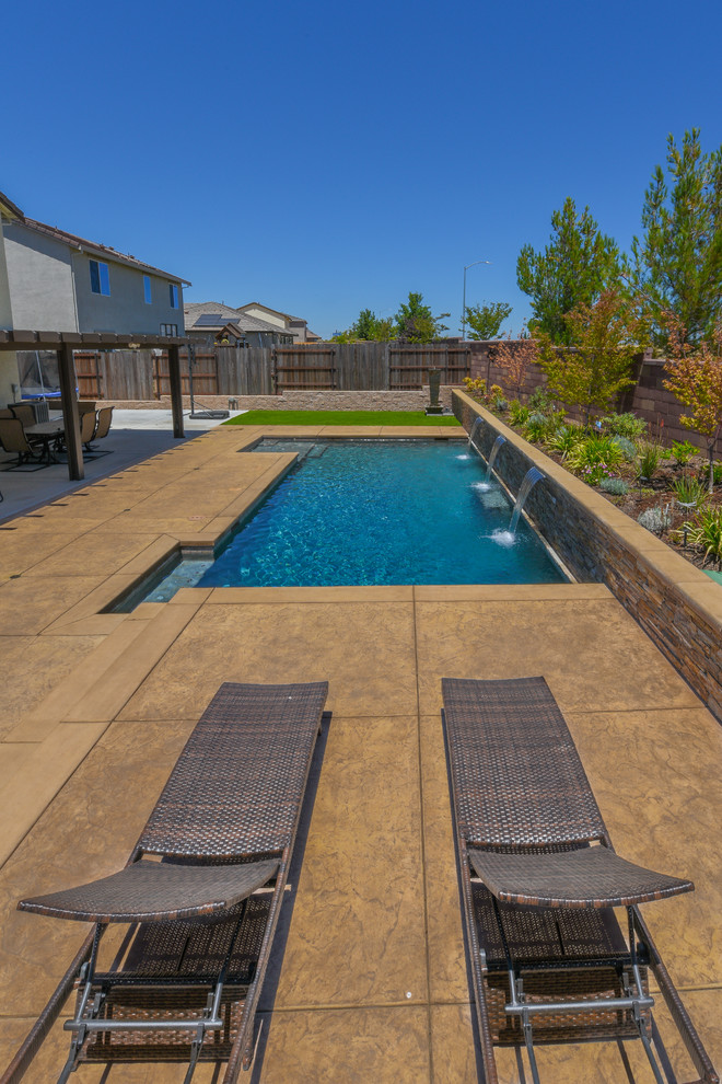 Esempio di una grande piscina contemporanea personalizzata dietro casa con fontane e pavimentazioni in pietra naturale