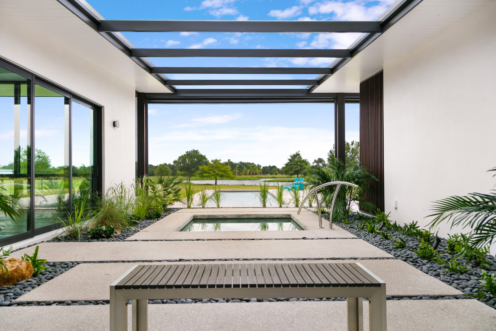 Diseño de piscinas y jacuzzis alargados contemporáneos grandes rectangulares en patio con losas de hormigón