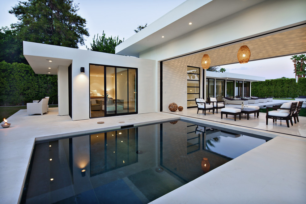 Immagine di una piscina minimalista con pavimentazioni in pietra naturale