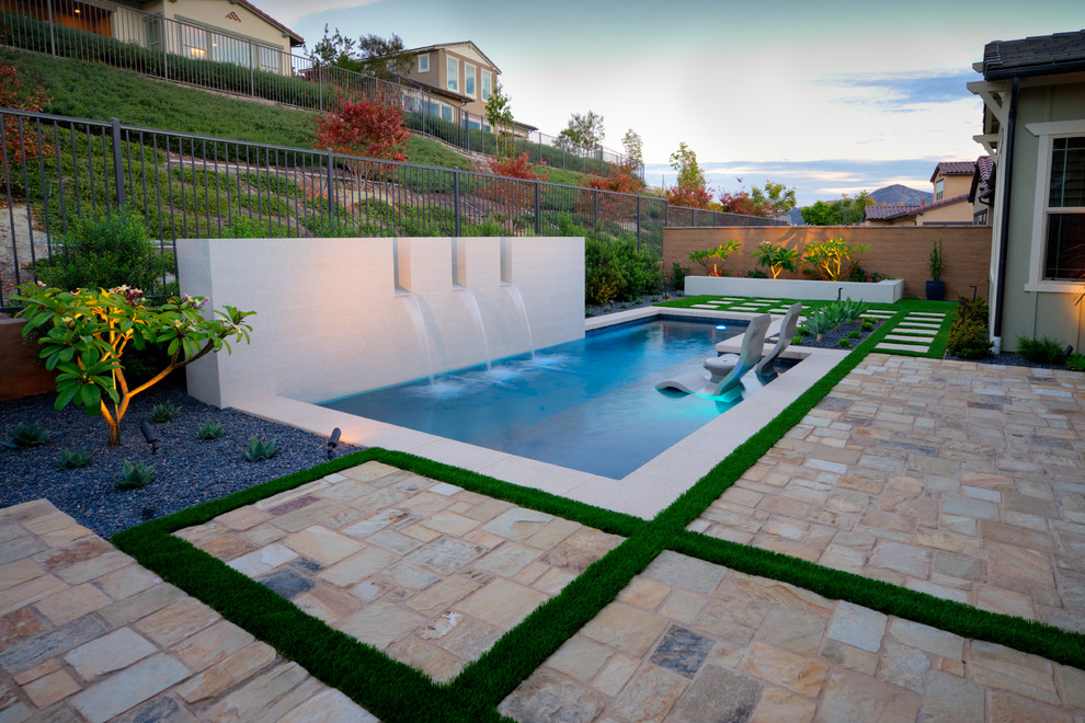 Immagine di una piccola piscina contemporanea rettangolare dietro casa con una vasca idromassaggio e pavimentazioni in pietra naturale