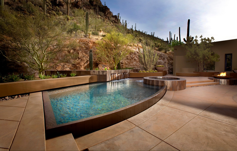 Design ideas for a custom shaped swimming pool in Phoenix with a water feature.