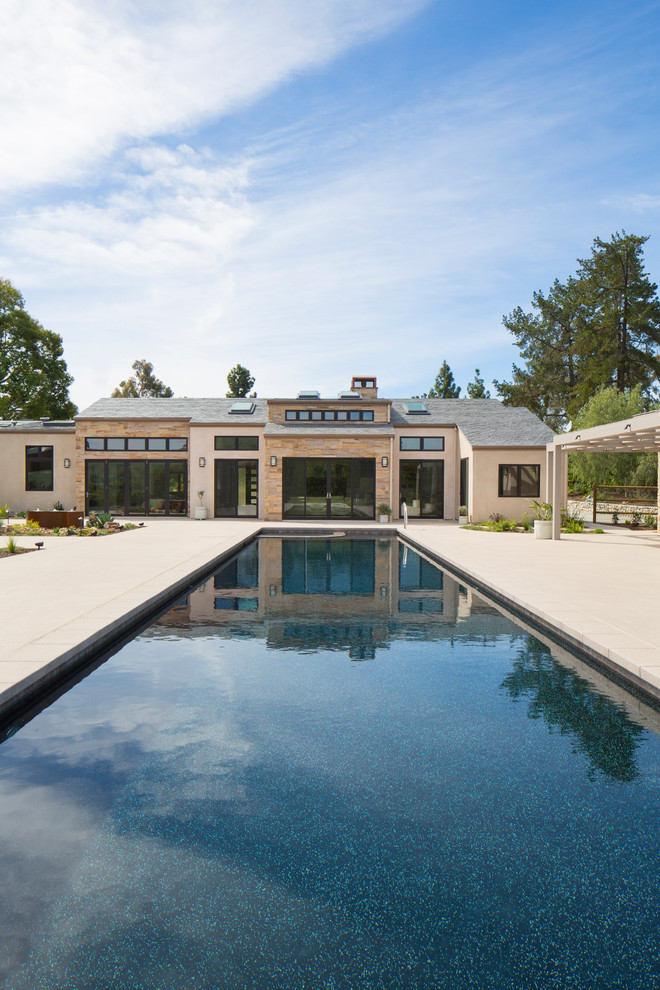 Foto de piscina tradicional renovada grande rectangular en patio trasero con suelo de baldosas