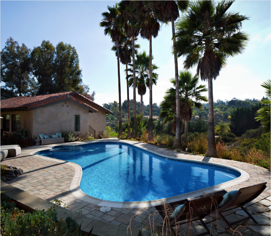 Aménagement d'une piscine arrière méditerranéenne en forme de haricot de taille moyenne avec des pavés en béton.