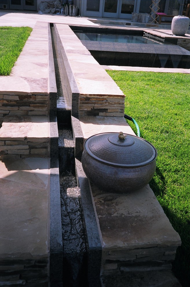 Ejemplo de piscinas y jacuzzis contemporáneos de tamaño medio a medida en patio trasero con adoquines de piedra natural