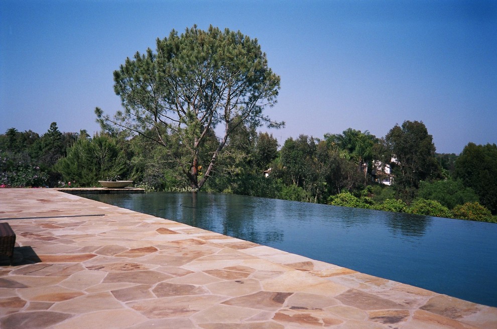 Großer Moderner Infinity-Pool hinter dem Haus in rechteckiger Form mit Wasserspiel und Natursteinplatten in San Diego