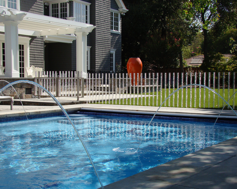 На фото: прямоугольный бассейн на заднем дворе в классическом стиле