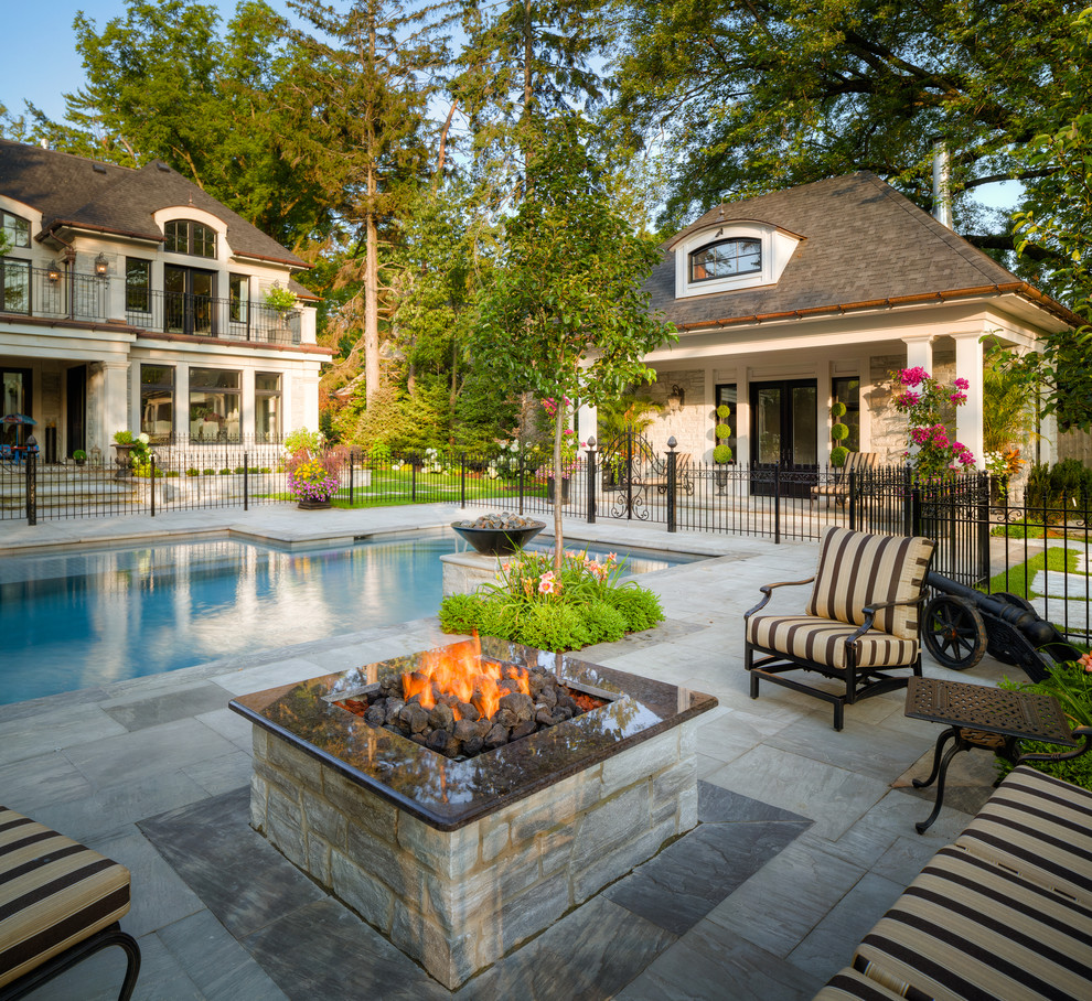 Идея дизайна: большой прямоугольный бассейн на заднем дворе в классическом стиле с домиком у бассейна и покрытием из каменной брусчатки
