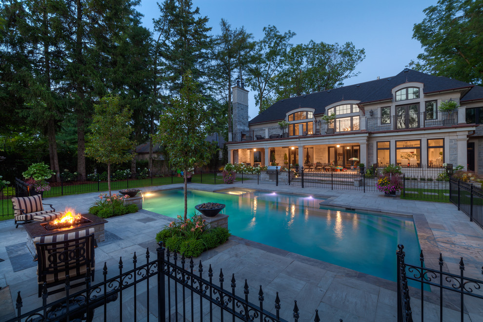 Стильный дизайн: большой прямоугольный бассейн на заднем дворе в классическом стиле с фонтаном и покрытием из каменной брусчатки - последний тренд