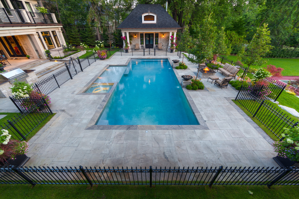 Idées déco pour une grande piscine arrière classique rectangle avec un point d'eau et des pavés en pierre naturelle.