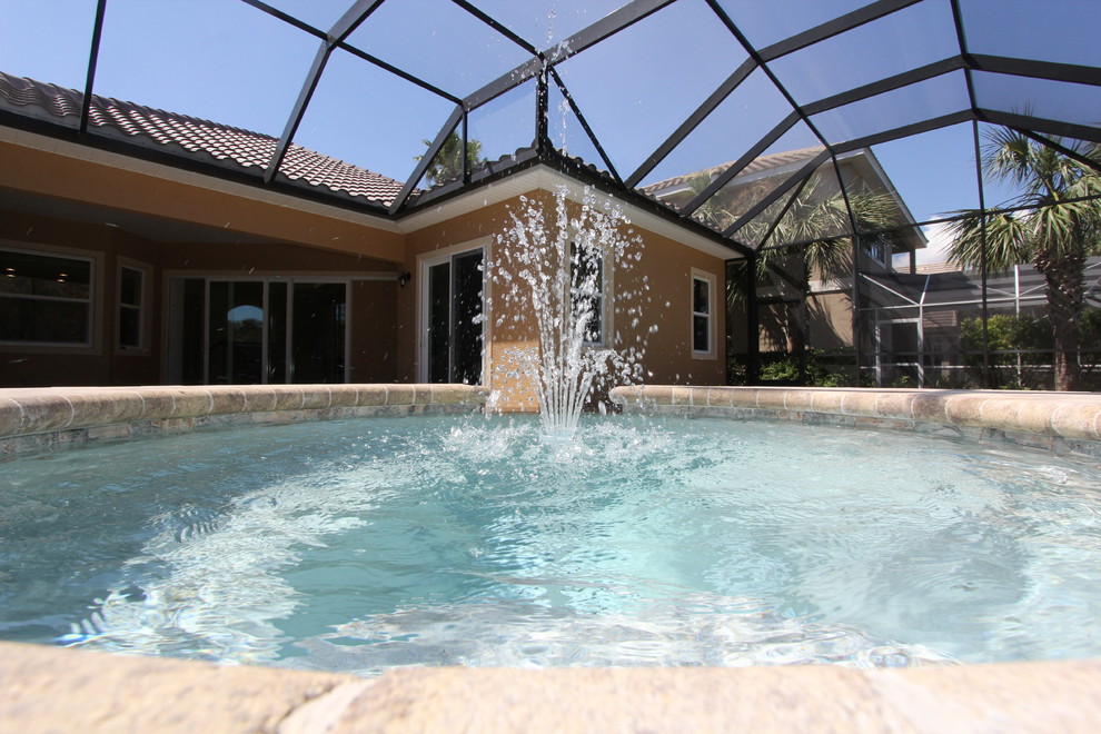 Photo of a large classic back kidney-shaped natural swimming pool in Orlando with a water feature and concrete paving.