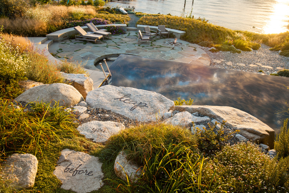 Beach style backyard stone and rectangular infinity pool photo in Seattle