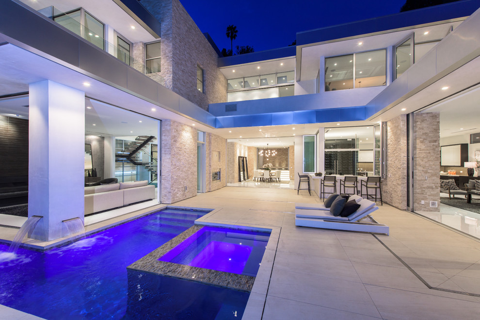 Moderner Infinity-Pool hinter dem Haus in rechteckiger Form mit Betonplatten in Los Angeles