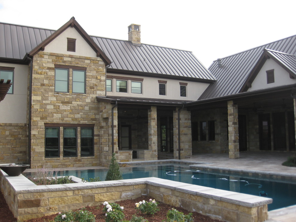 Inspiration for a large classic back custom shaped lengths swimming pool in Dallas with a water feature and concrete paving.