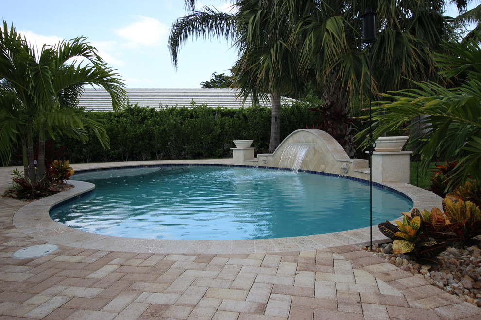 Imagen de piscina con fuente natural clásica renovada de tamaño medio a medida en patio trasero con adoquines de ladrillo