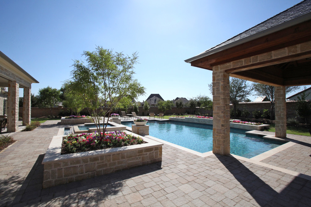 Idee per una grande piscina minimalista personalizzata dietro casa con fontane e pavimentazioni in pietra naturale