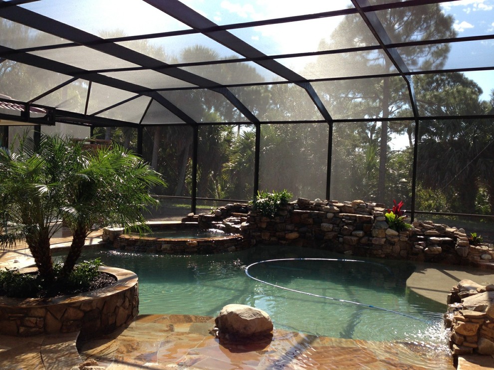 Idee per una grande piscina coperta naturale tropicale personalizzata con una dépendance a bordo piscina e pavimentazioni in pietra naturale