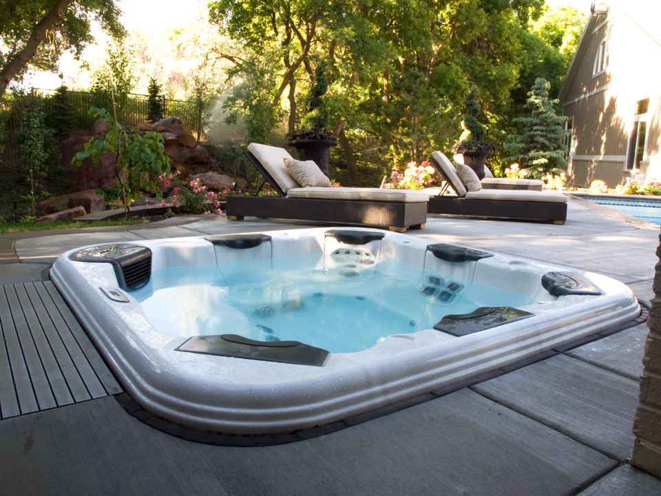 Свежая идея для дизайна: прямоугольный бассейн среднего размера на заднем дворе в стиле неоклассика (современная классика) с джакузи и покрытием из декоративного бетона - отличное фото интерьера
