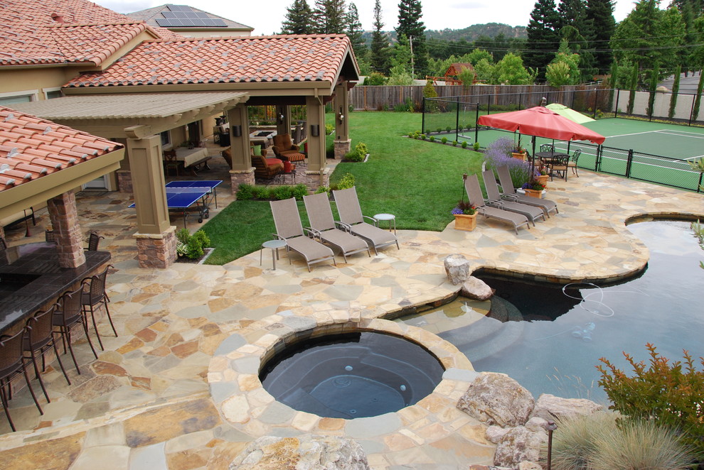 Foto di una piscina mediterranea personalizzata con pavimentazioni in pietra naturale