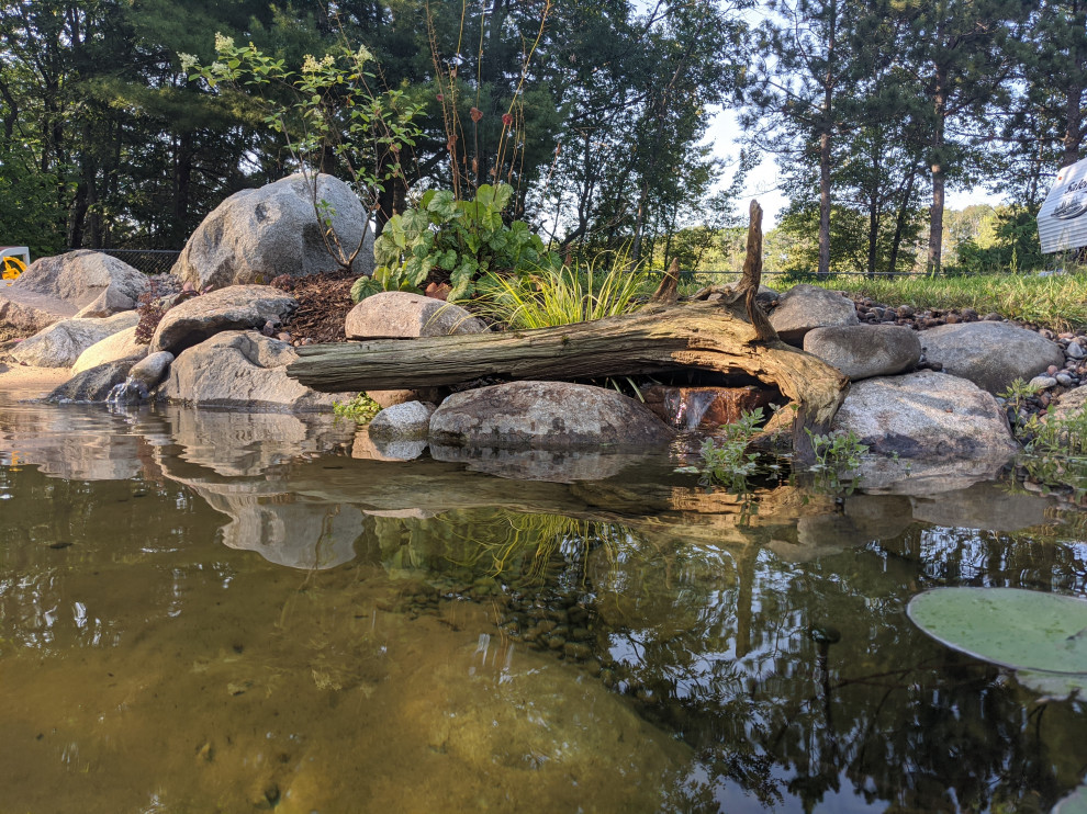 Cette photo montre une très grande piscine naturelle et arrière montagne sur mesure avec un point d'eau et des pavés en pierre naturelle.