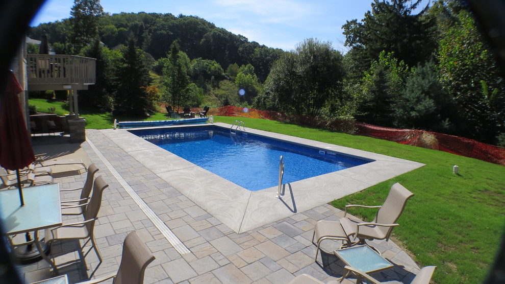 Photo of a large modern back rectangular swimming pool in Other with stamped concrete.