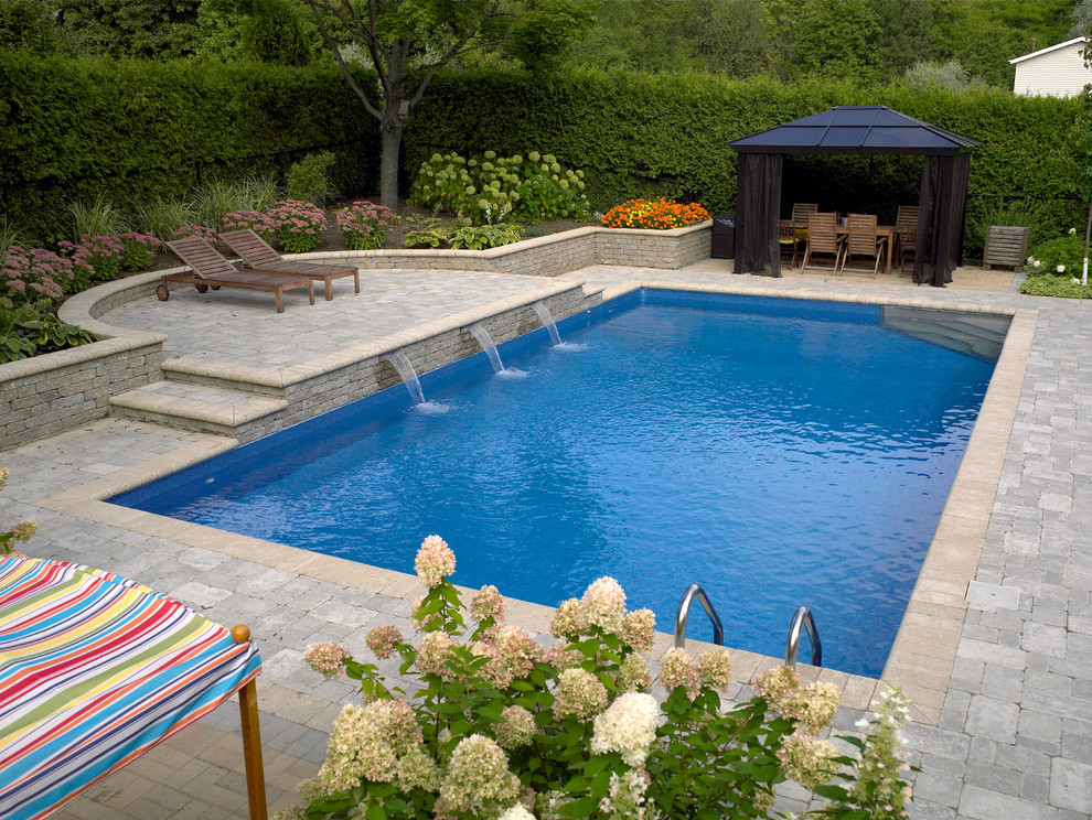Пример оригинального дизайна: большой естественный, прямоугольный бассейн на заднем дворе в стиле модернизм с фонтаном и мощением клинкерной брусчаткой