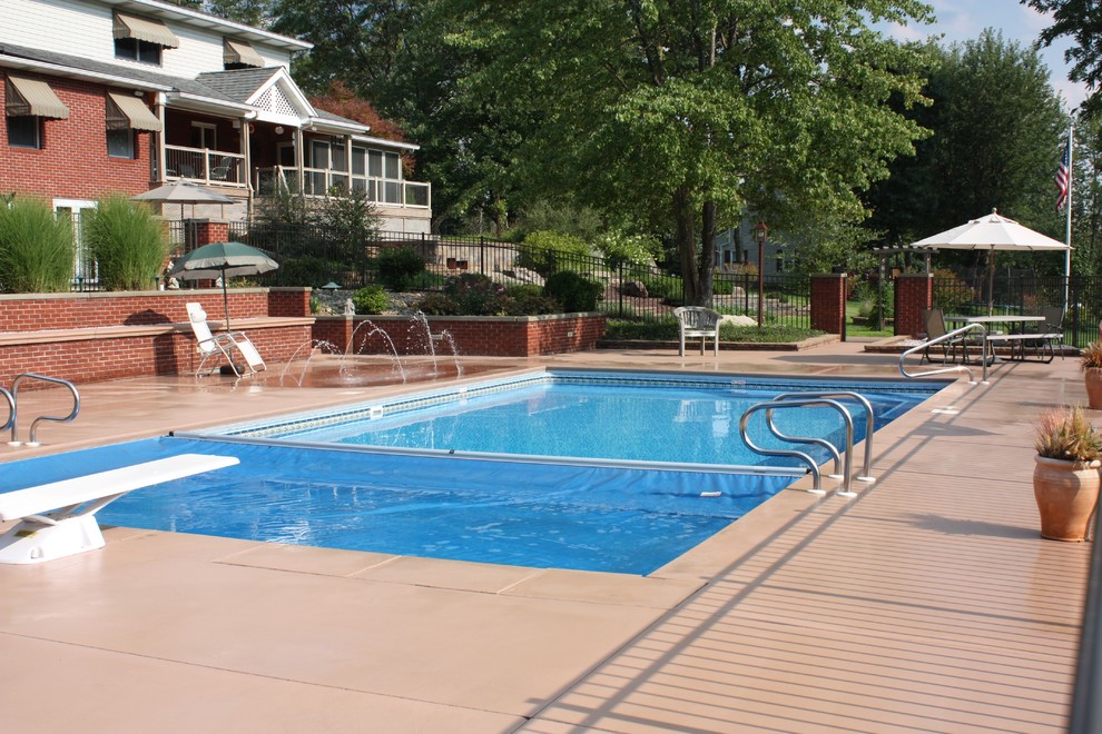 Идея дизайна: большой спортивный, прямоугольный бассейн на заднем дворе в классическом стиле с покрытием из бетонных плит