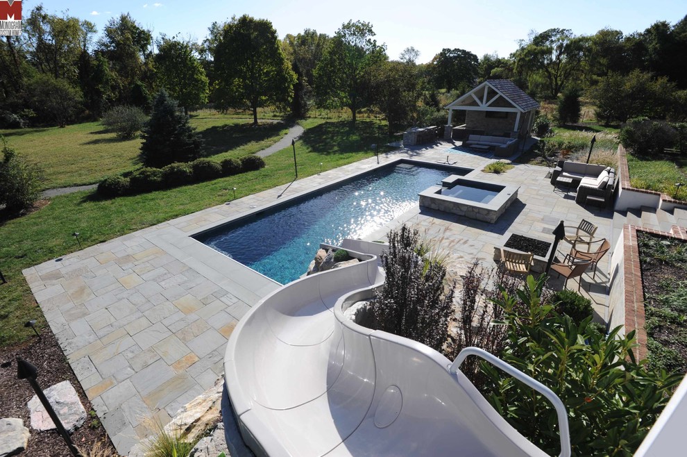 Imagen de piscina con tobogán alargada contemporánea grande rectangular en patio trasero