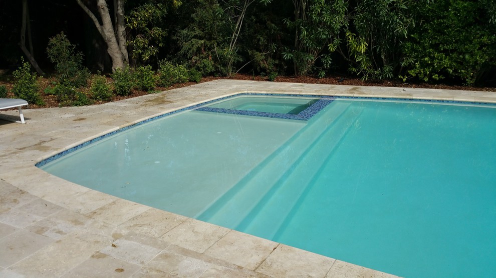 Ejemplo de piscinas y jacuzzis alargados minimalistas de tamaño medio rectangulares en patio trasero con suelo de baldosas